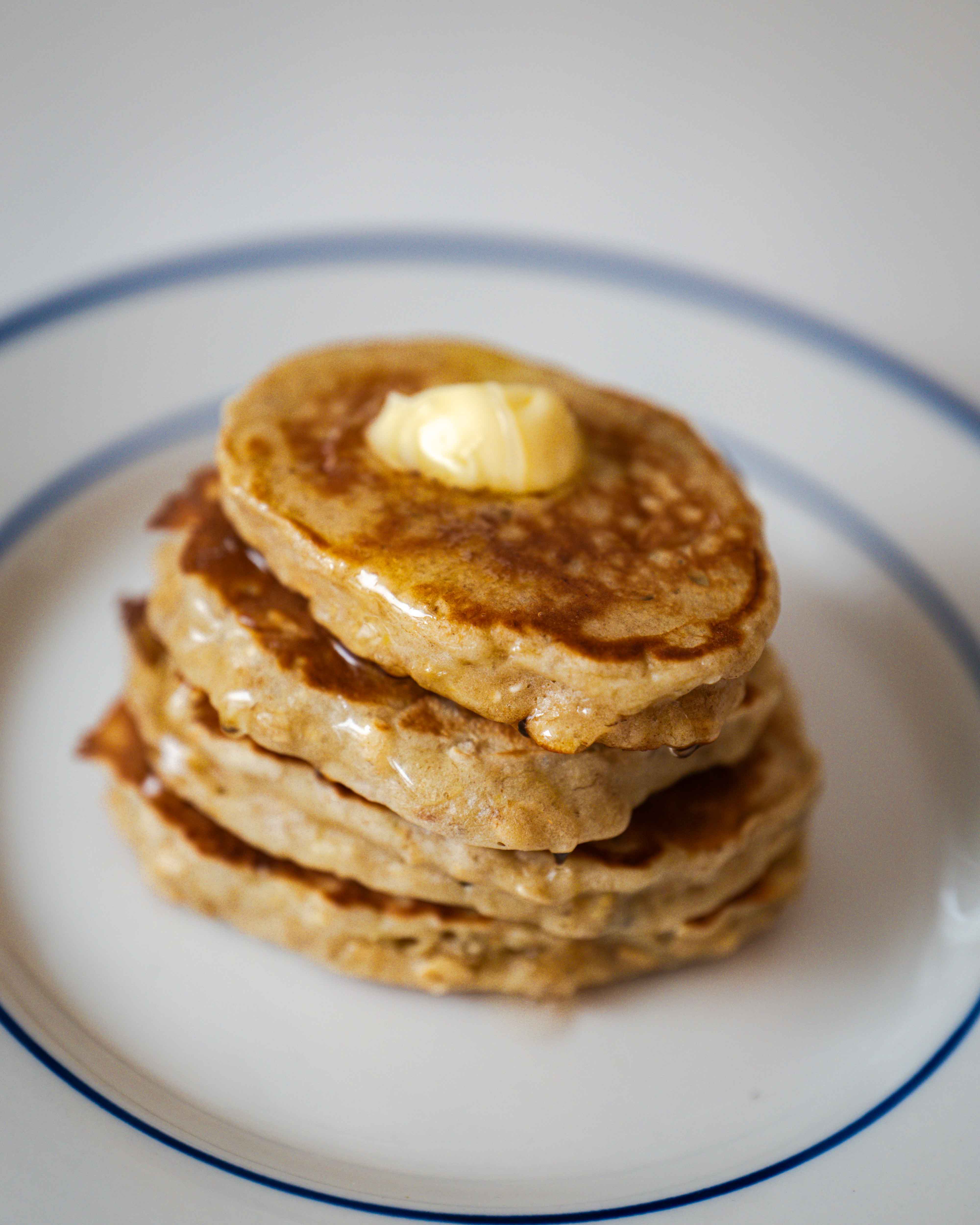 Bananpandekager, smukt toppet med flydende honning og en smule smør. En fest for smagsløgene og et kunstværk på tallerkenen. 🍌🥞 #LækkerMorgenmad
