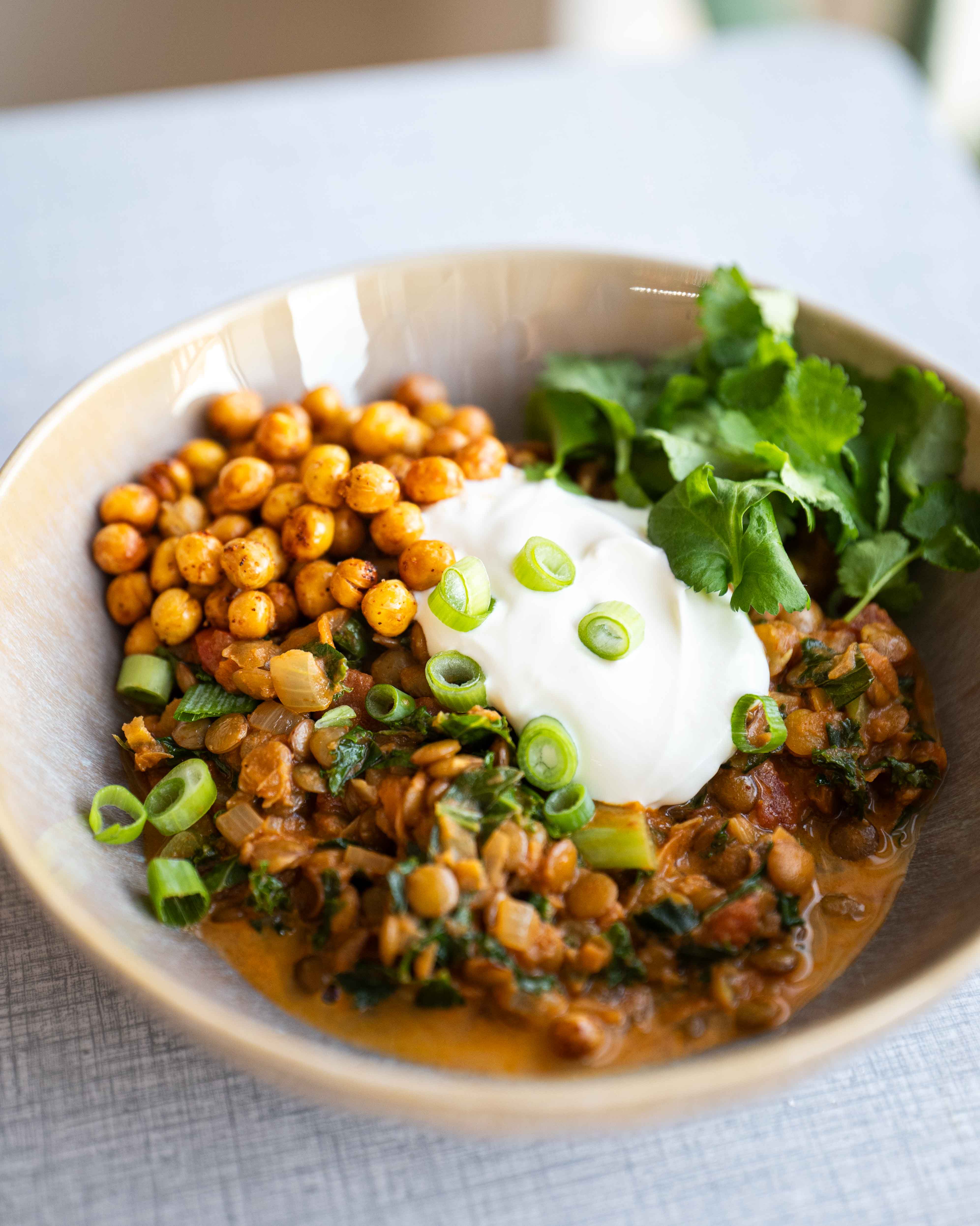 En appetitvækkende skål med grøn dhal, fuld af smag og næring. Toppet med en generøs skefuld creme fraiche, sprøde ristede ingridærter, friske forårsløg og aromatisk koriander. En farverig og velsmagende vegetarisk ret, der pirrer både syns- og smagssanserne.
