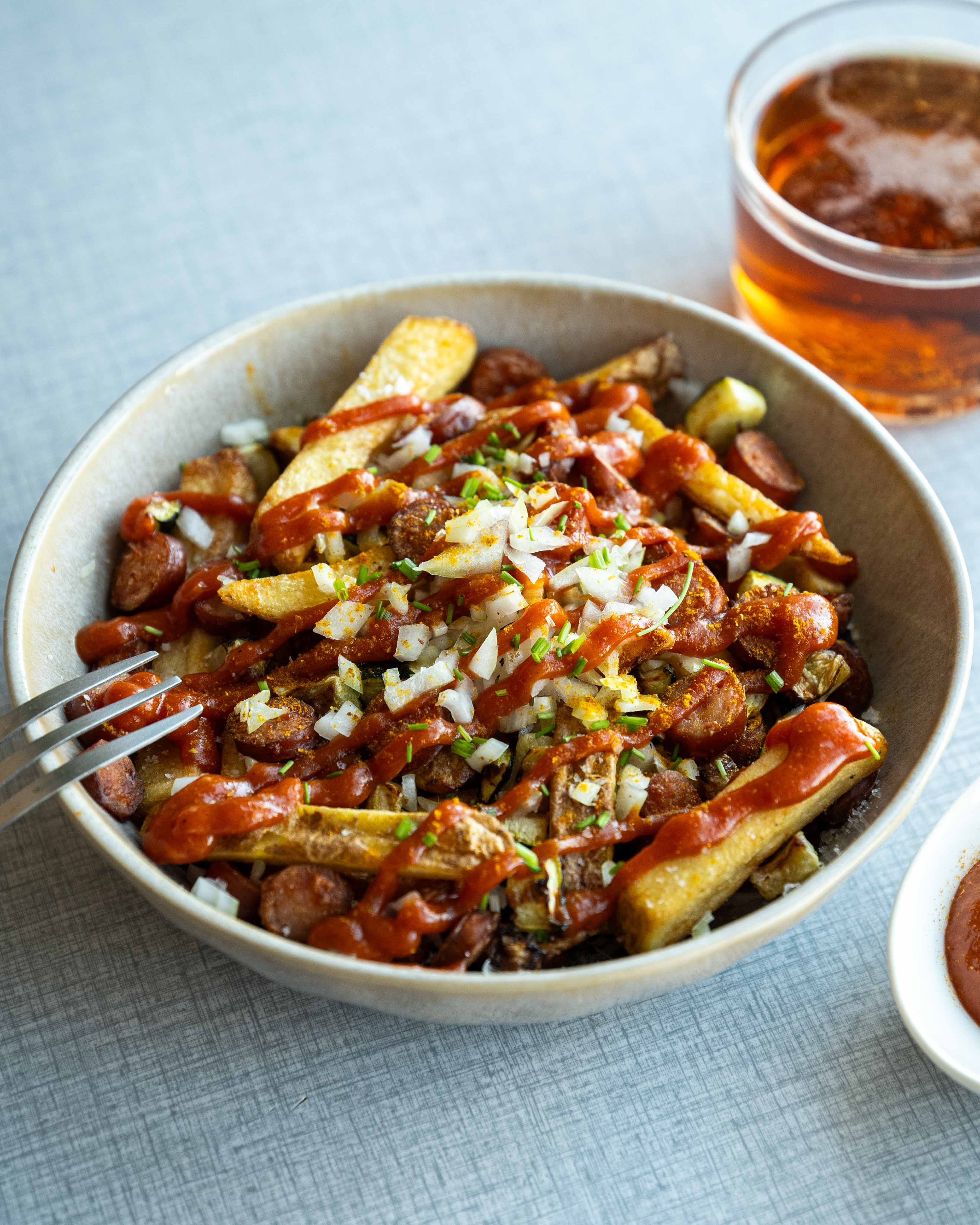 Pølsemix i airfryer med sprøde pomfritter, pølser og squash, toppet med karryketchup, friskhakket løg og purløg.