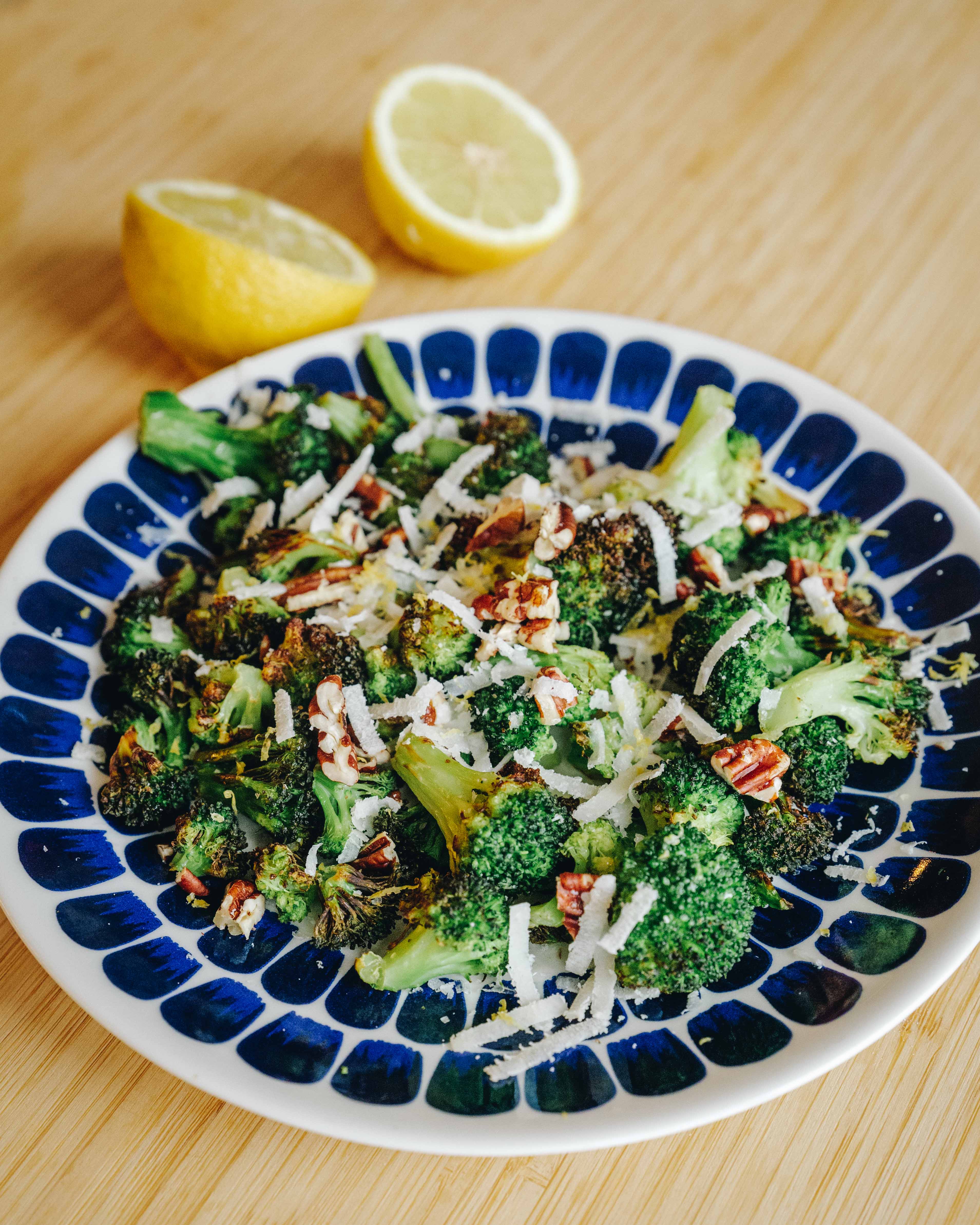 Broccoli i airfryer, toppet med hakkede nødder, revet parmesan og citron.