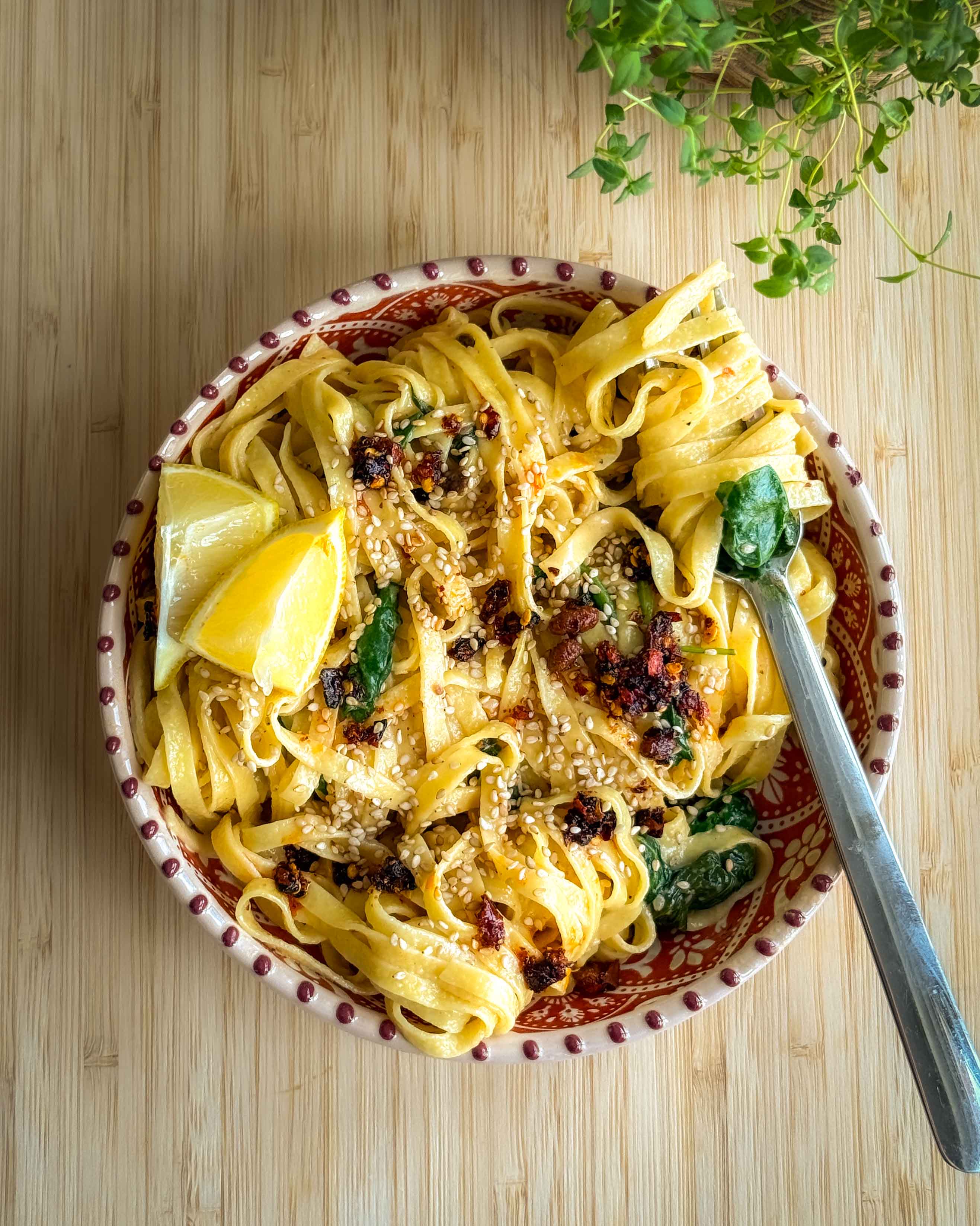En skål cremet crispy chili pasta med spinat, parmesan og frisk citronsaft, serveret på en lys tallerken.