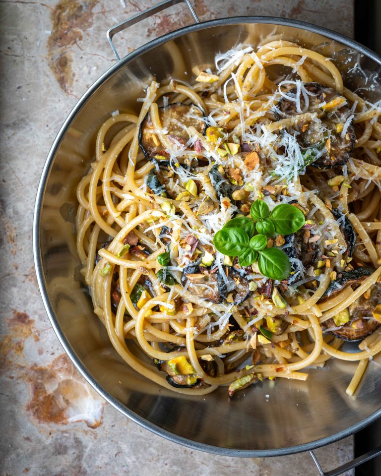 Spaghetti med squash, pecorino, basilikum og hakkede pistacienødder i en pastatallerken.