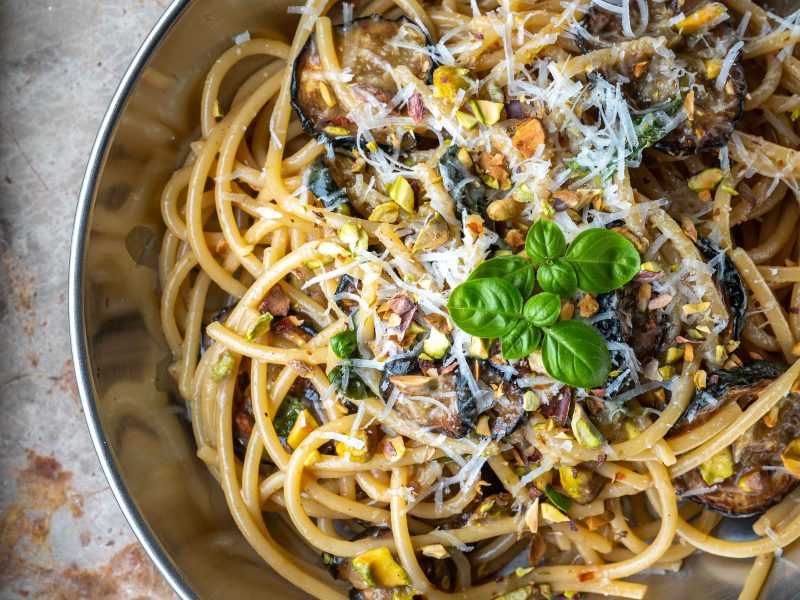 Spaghetti med squash, pecorino, basilikum og hakkede pistacienødder i en pastatallerken.