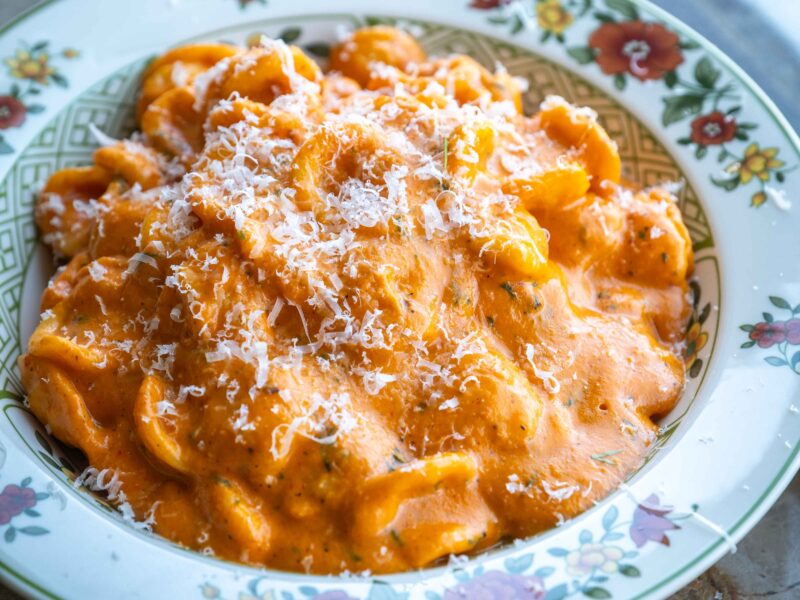 Cremet pasta med hytteost, ristet peberfrugt, cherrytomater, parmesan og dild i en skål.